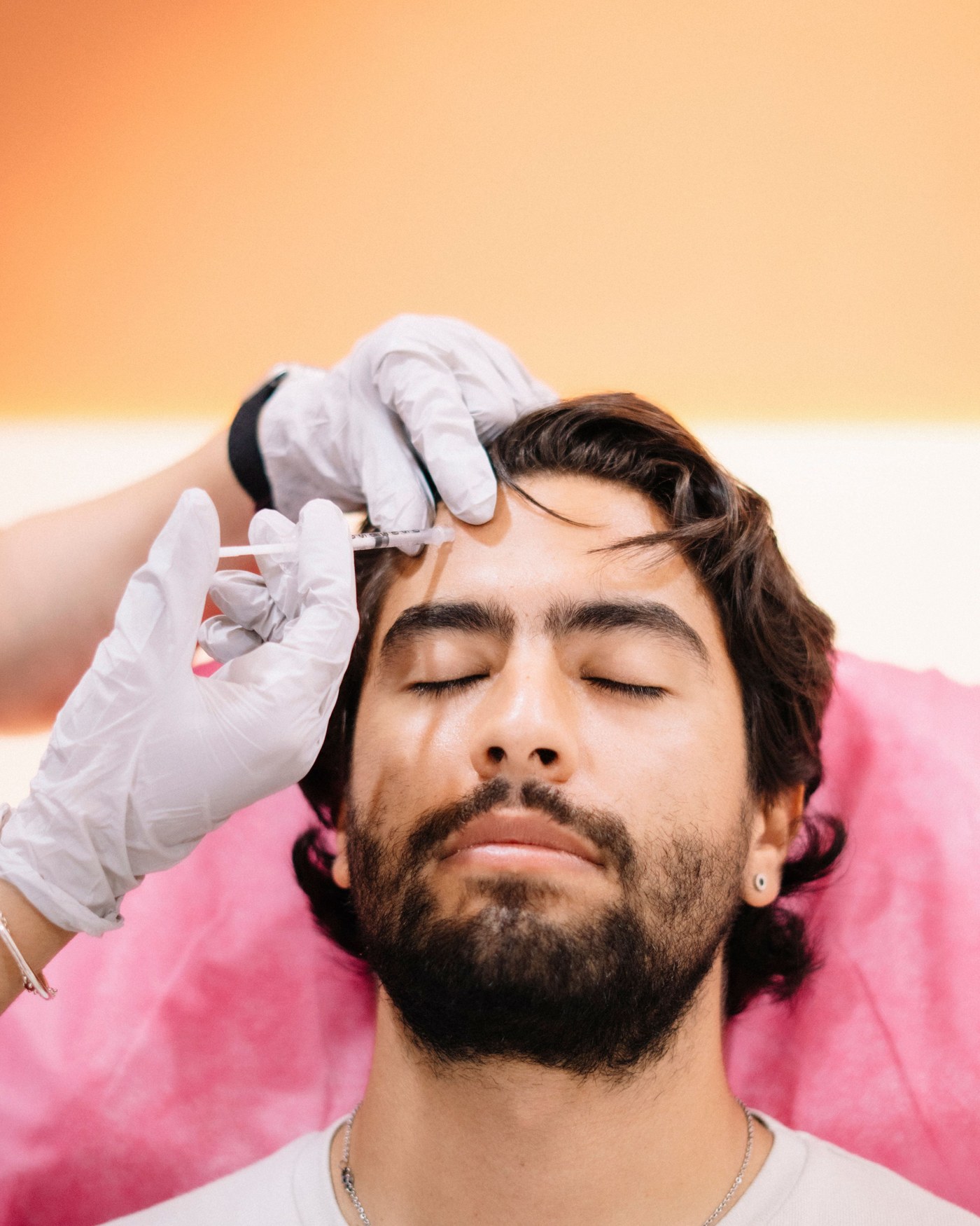 Un hombre recibe una inyección estética en la frente